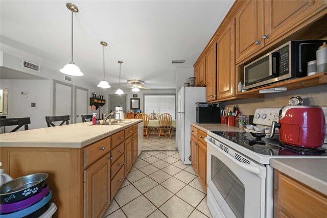 kitchen with a kitchen island, sink, decorative light fixtures, white appliances, and ceiling fan