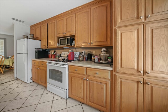 kitchen featuring light tile patterned floors and white appliances