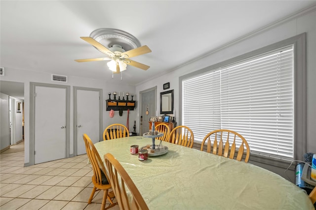 dining space featuring crown molding, light tile patterned flooring, and ceiling fan