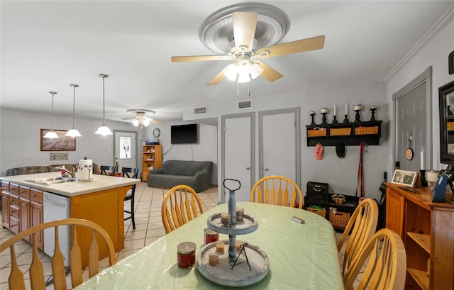 tiled dining area featuring ceiling fan, ornamental molding, and sink