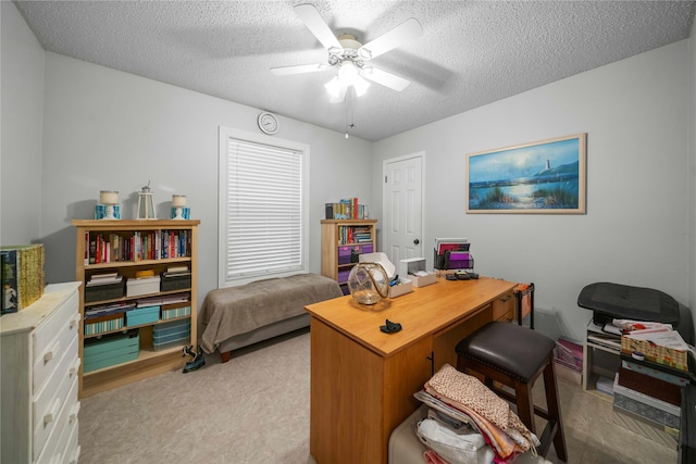 carpeted home office with a textured ceiling and ceiling fan