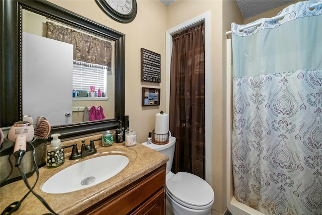 bathroom with vanity, toilet, walk in shower, and a textured ceiling