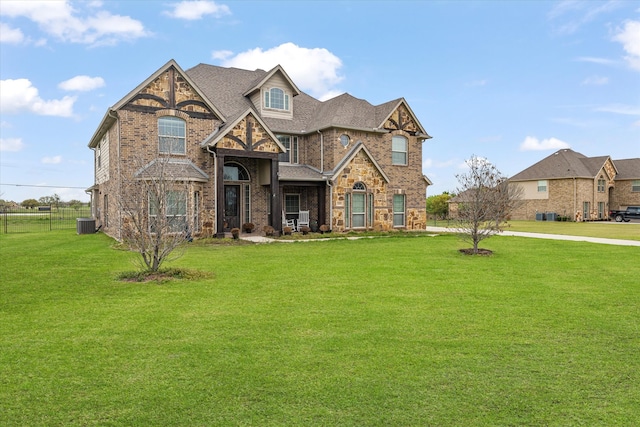 view of front of property with central air condition unit and a front lawn