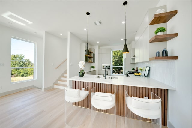 living room featuring light hardwood / wood-style flooring, ceiling fan, and sink