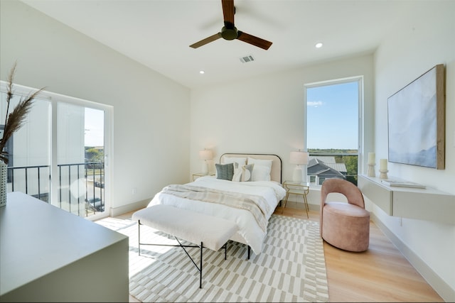 bedroom with access to outside, light hardwood / wood-style floors, multiple windows, and ceiling fan