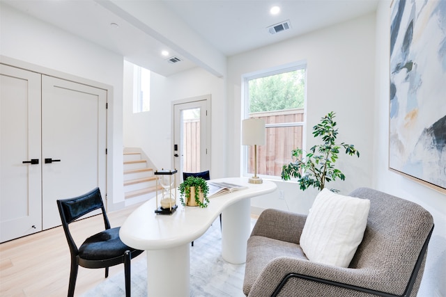 interior space featuring beamed ceiling and light hardwood / wood-style floors