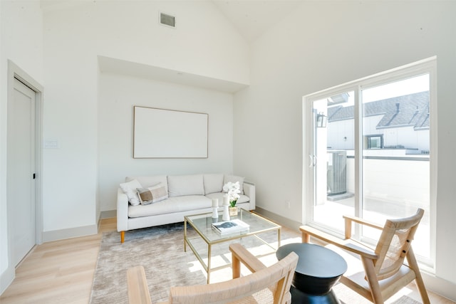 living room featuring light hardwood / wood-style floors and high vaulted ceiling