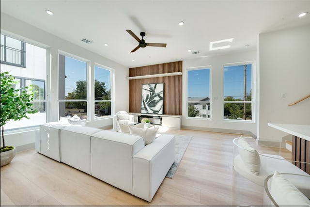 living room featuring ceiling fan, light hardwood / wood-style floors, and sink