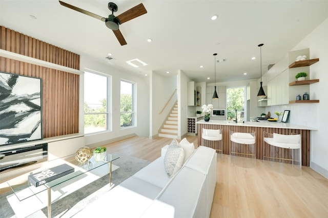 living room with light hardwood / wood-style flooring and ceiling fan