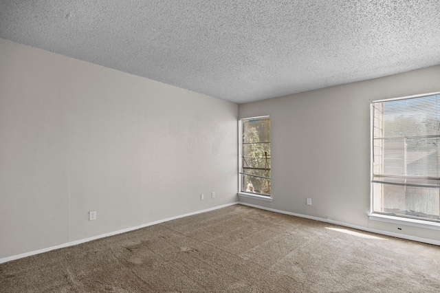 carpeted spare room with a textured ceiling