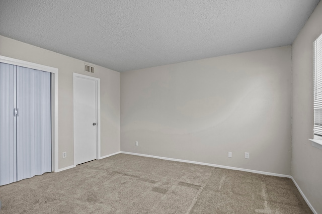 unfurnished bedroom with a textured ceiling and carpet flooring