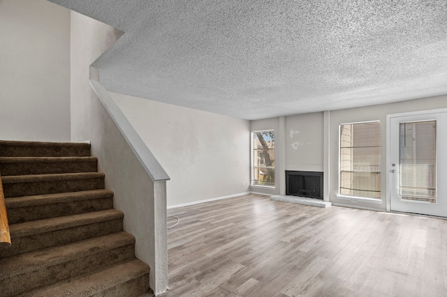 unfurnished living room with a textured ceiling and hardwood / wood-style floors