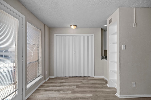 interior space featuring a textured ceiling and light hardwood / wood-style floors