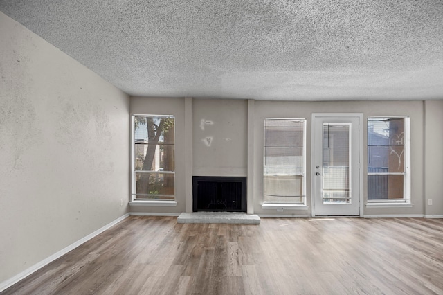 unfurnished living room featuring a textured ceiling and hardwood / wood-style flooring