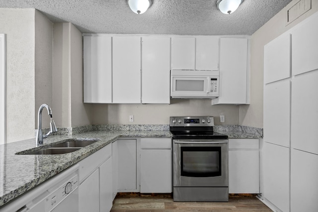 kitchen with white cabinets, sink, and white appliances