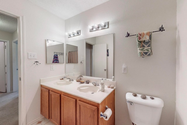 bathroom with vanity, a textured ceiling, and toilet