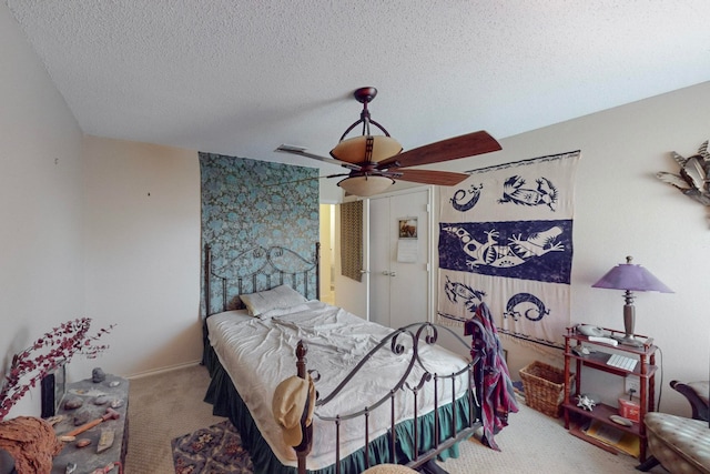 carpeted bedroom featuring a textured ceiling and ceiling fan