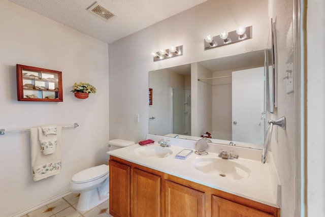 bathroom featuring toilet, tile patterned flooring, vanity, a textured ceiling, and walk in shower