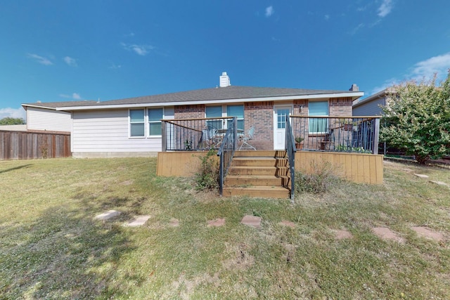 view of front of home with a wooden deck and a front lawn