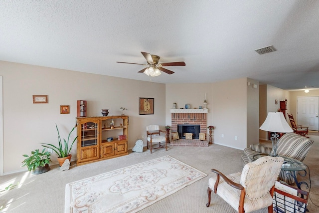 living room with light carpet, a textured ceiling, a fireplace, and ceiling fan