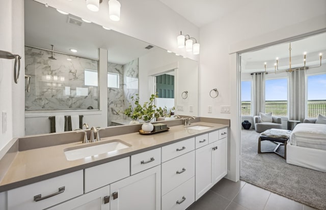 bathroom featuring a tile shower, a chandelier, vanity, and tile patterned flooring