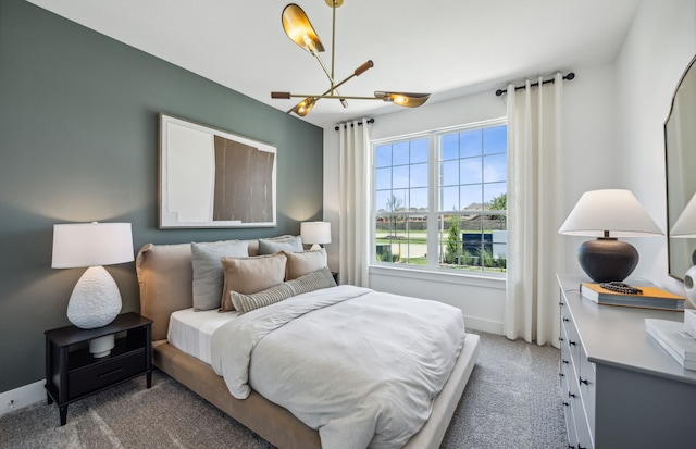 carpeted bedroom featuring a notable chandelier