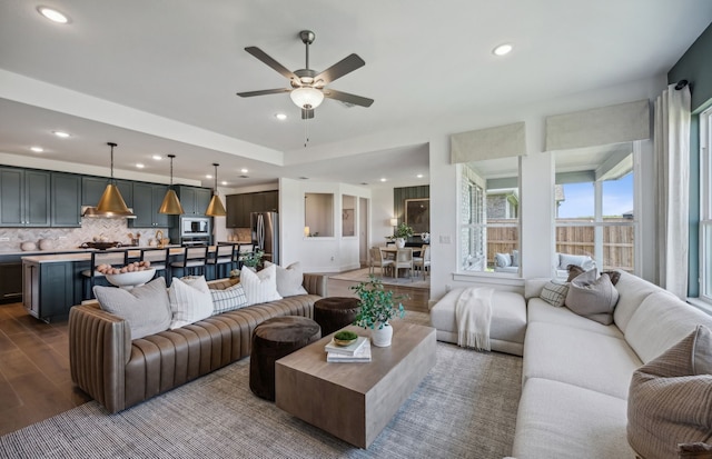 living room featuring hardwood / wood-style floors and ceiling fan