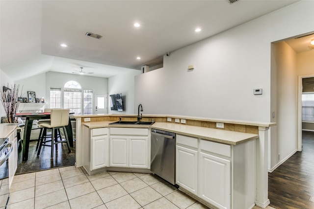 kitchen with sink, appliances with stainless steel finishes, white cabinetry, and light hardwood / wood-style floors