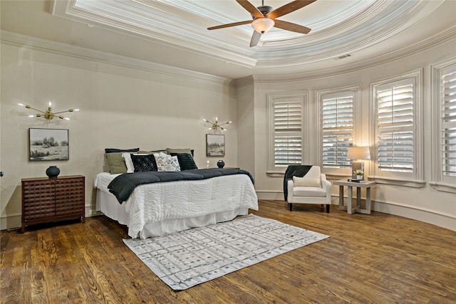 bedroom featuring dark hardwood / wood-style floors, ornamental molding, a tray ceiling, and ceiling fan with notable chandelier