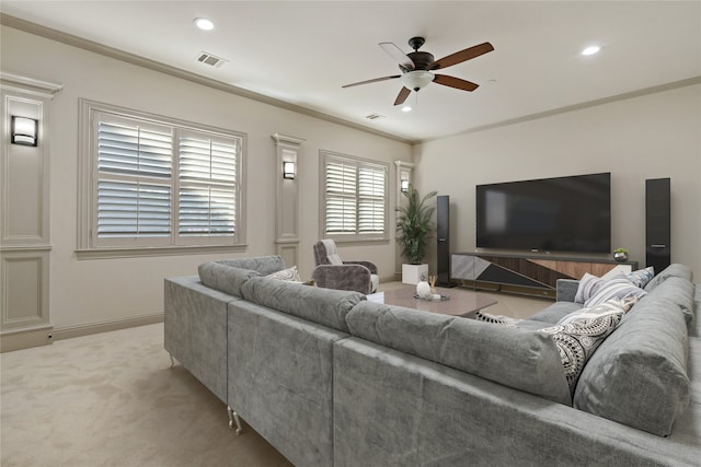 carpeted living room with ornamental molding and ceiling fan