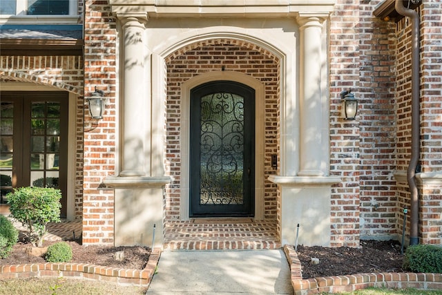 view of exterior entry with brick siding and french doors