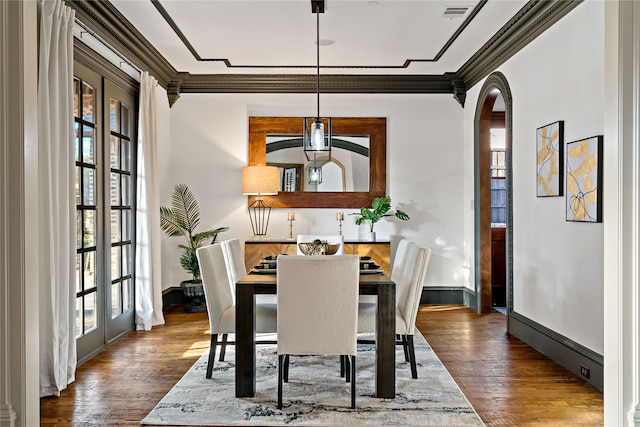 dining room featuring crown molding, a wealth of natural light, and dark hardwood / wood-style flooring