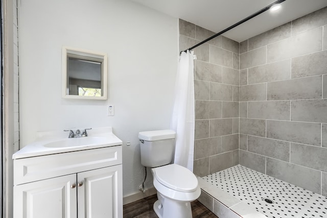 bathroom with a shower with shower curtain, vanity, hardwood / wood-style flooring, and toilet