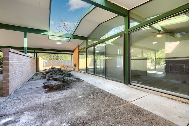 unfurnished sunroom featuring ceiling fan and lofted ceiling