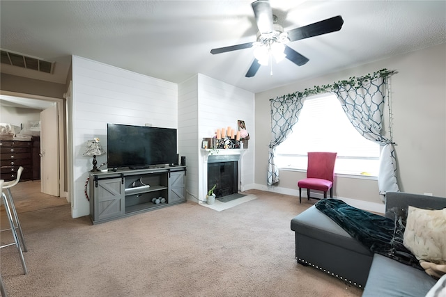 living room featuring light carpet, a textured ceiling, and ceiling fan