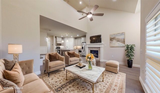 living room featuring ceiling fan, sink, high vaulted ceiling, and hardwood / wood-style floors