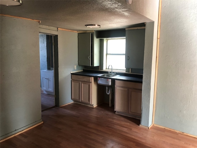 kitchen featuring a textured ceiling, sink, and dark hardwood / wood-style floors