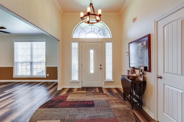 entryway with crown molding, ceiling fan with notable chandelier, and dark hardwood / wood-style flooring