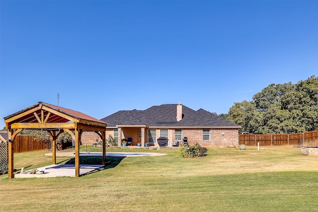 back of house with a patio, a gazebo, a swimming pool, and a lawn