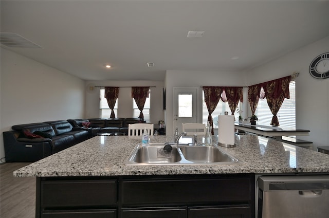 kitchen with dishwasher, a kitchen island with sink, sink, and plenty of natural light