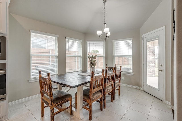 tiled dining room featuring a notable chandelier, vaulted ceiling, and plenty of natural light