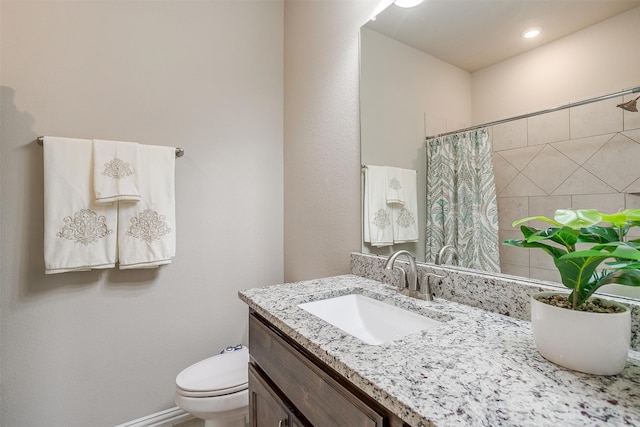 bathroom featuring toilet, walk in shower, and vanity