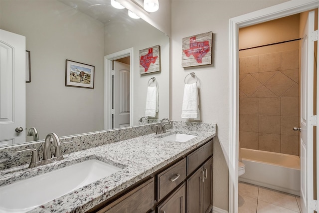 full bathroom featuring vanity, tiled shower / bath, toilet, and tile patterned flooring