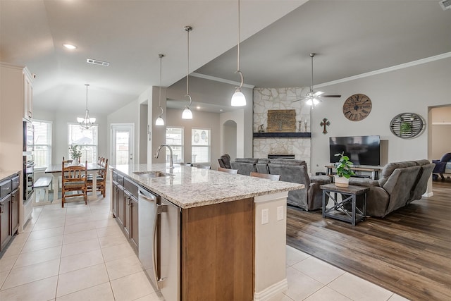 kitchen featuring a kitchen island with sink, sink, light wood-type flooring, and a wealth of natural light