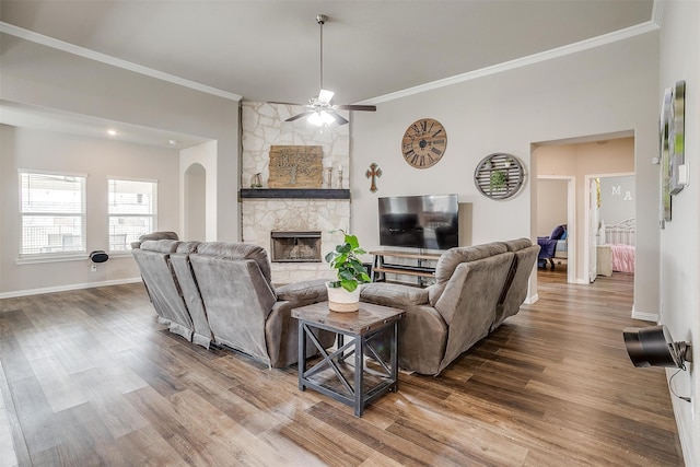 living room featuring crown molding, a fireplace, hardwood / wood-style flooring, and ceiling fan