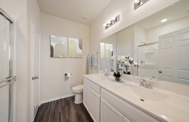 bathroom featuring vanity, toilet, walk in shower, and hardwood / wood-style floors