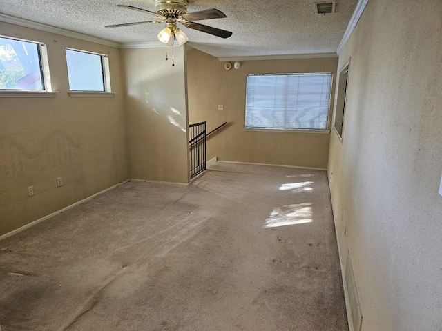 interior space featuring a textured ceiling, light colored carpet, ceiling fan, and ornamental molding