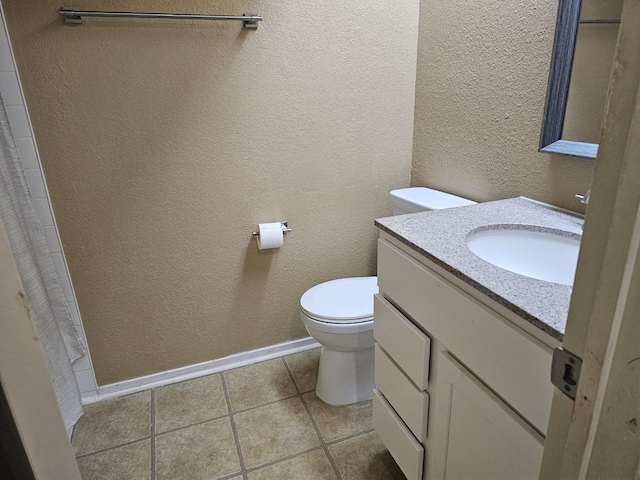 bathroom featuring tile patterned floors, vanity, and toilet