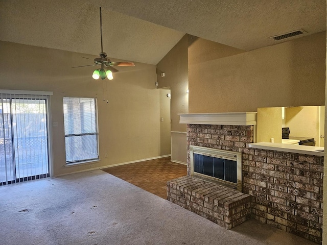 living room with a textured ceiling, high vaulted ceiling, a brick fireplace, and ceiling fan