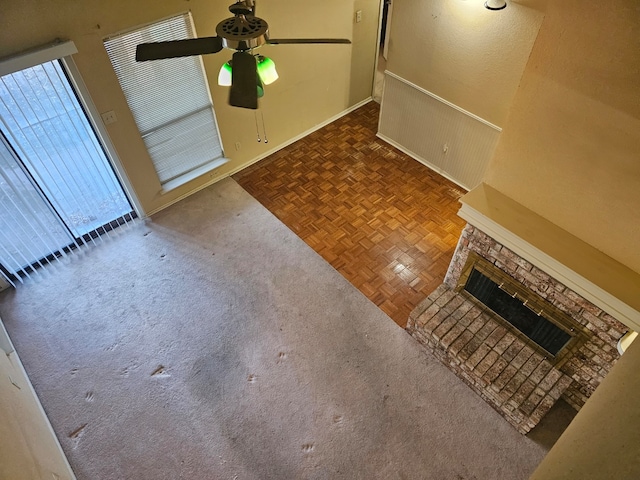 unfurnished living room with ceiling fan, parquet floors, and a fireplace